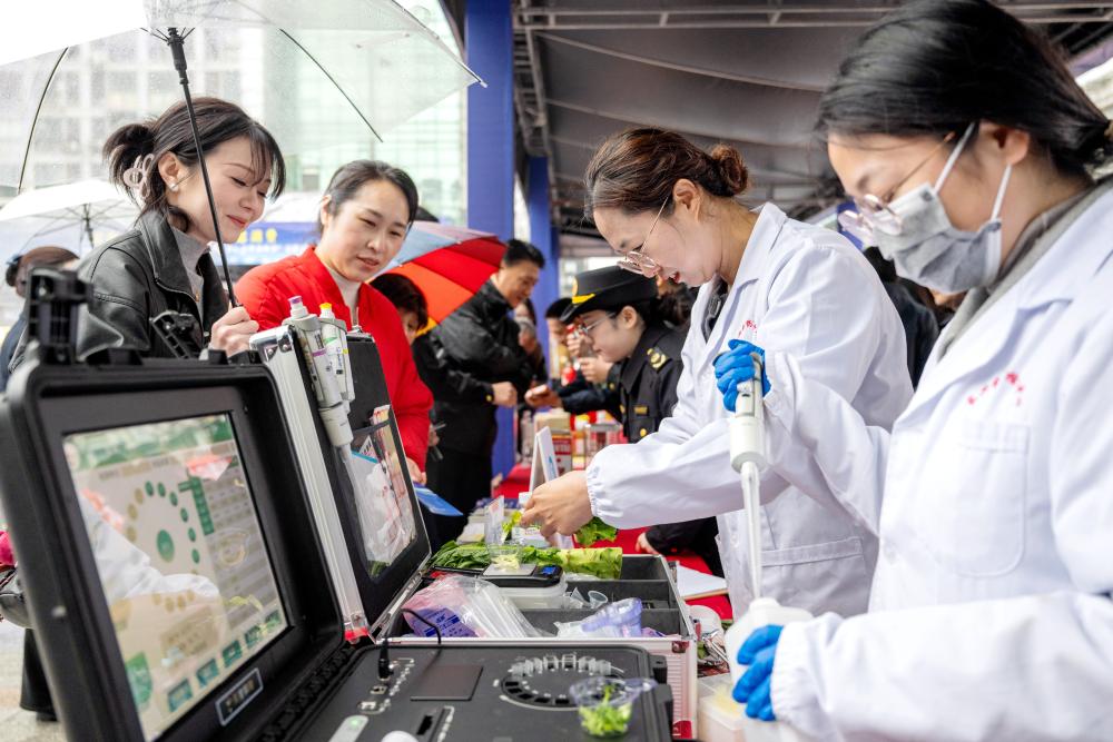 在浙江省湖州市长兴县放心消费嘉年华公益活动现场，该县食品药品检验检测中心工作人员为市民提供免费果蔬检测服务（2025年3月15日摄）。新华社发（谭云俸 摄）