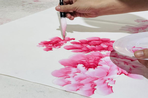 (村民正在绘制牡丹画 图/环球网记者 张寒玥 摄)