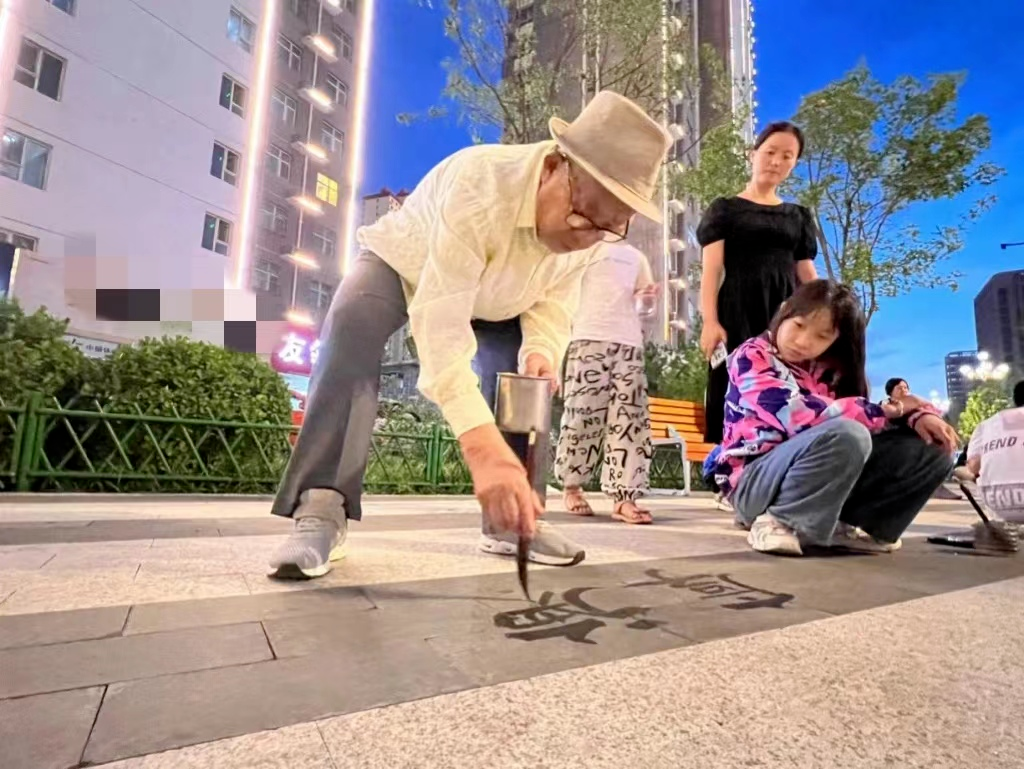 楊洪祿在廣場上教書法