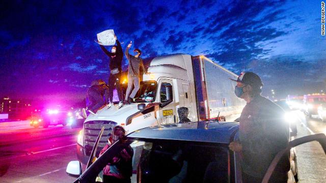 奥克兰示威者29日晚爬上一辆卡车。图源：美联社