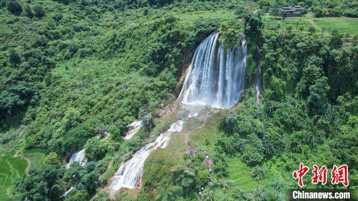 远眺三叠岭瀑布，百米飞瀑与不远处的古屋相映成趣，如同世外桃源。陈冠言 摄