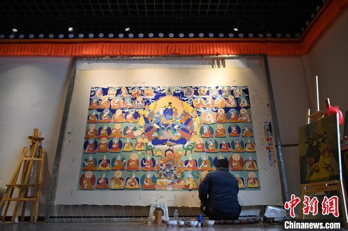 甘肃甘南藏族自治州夏河县唐卡小镇，画师旦正嘉席地而坐绘制唐卡。(资料图)中新社记者 九美旦增 摄