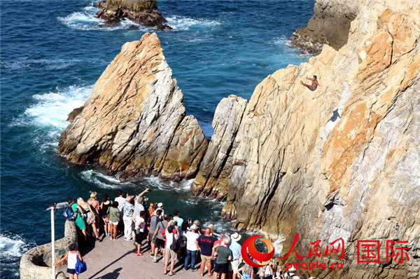 游客在观景台上观赏与拍照悬崖跳水表演 于世文 摄