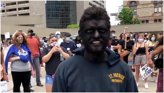 抗议人群中“涂黑脸”的男子
