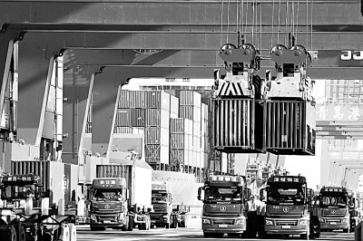 山东港口青岛前湾港外贸集装箱码头，货轮在装卸集装箱。俞方平摄/光明图片