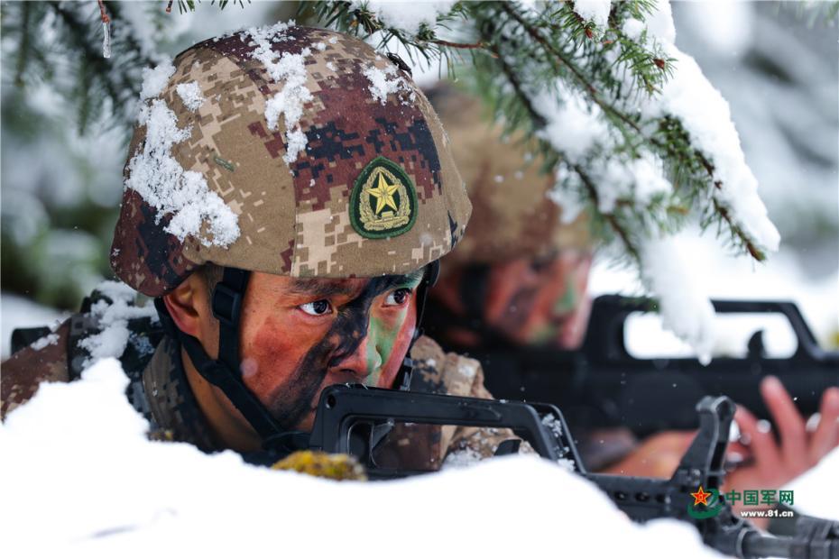 图为与战士们在雪地潜伏.