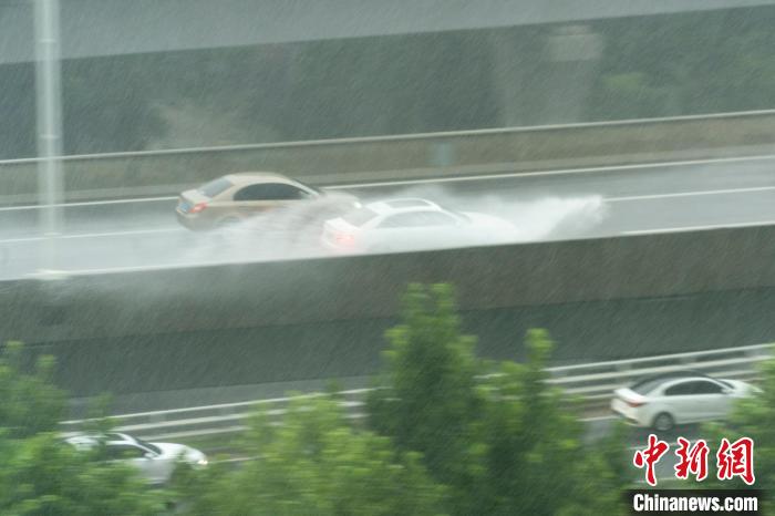 图为河南省郑州市北三环高架桥车辆在暴雨中行驶。中新社记者 李超庆 摄