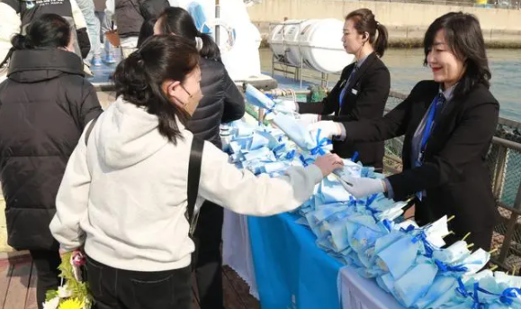 参与海葬的市民接过花束(沈阳市民政局供图）