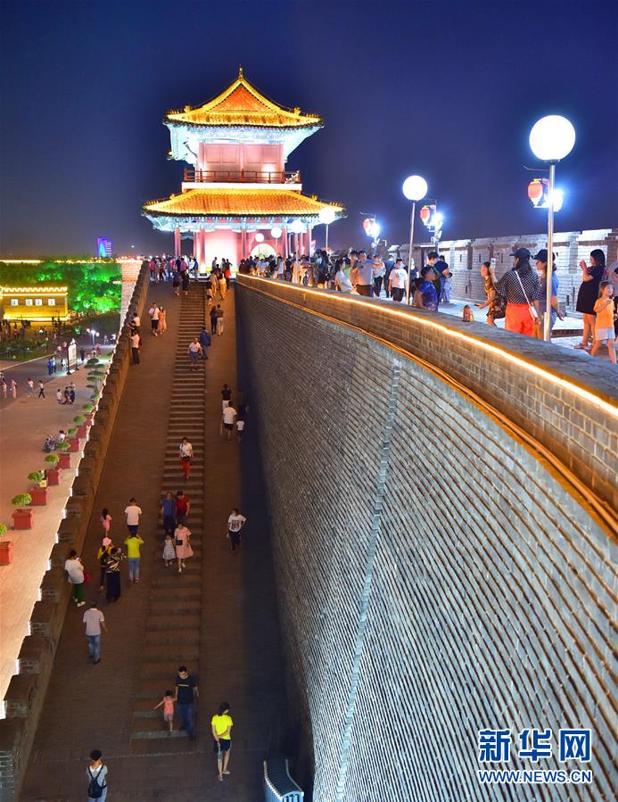 6月3日晚，河北正定古城南城门在霓虹灯的映衬下魅力尽显，人们踏着夜色欣赏古城风貌。新华社发（张晓峰 摄）