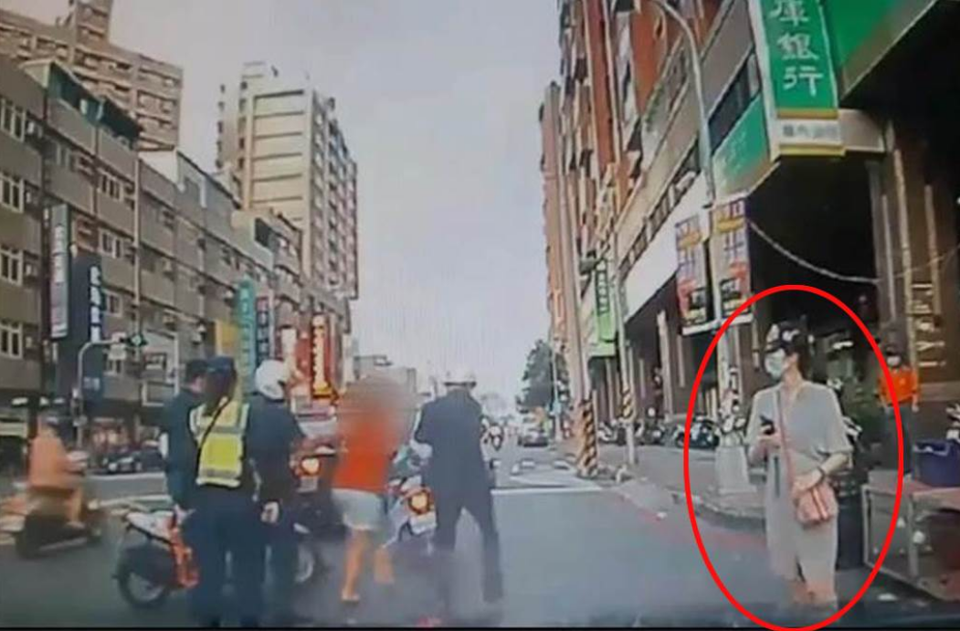 高雄街头，一妇女脚踹李明璇汽车车身，李明璇的丈夫与该妇女理论时，李明璇（红圈）在旁用手机录像。图自台媒