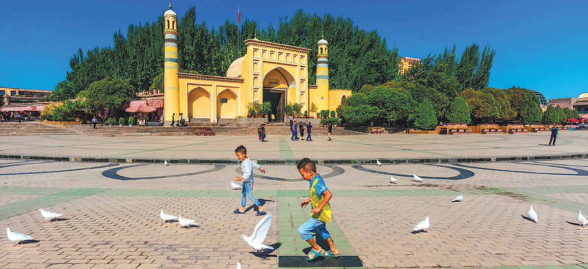 %_editorone_%Children feed pigeons in a square in front of a mosque in the city of Kashgar, Xinjiang Uygur autonomous region, on Aug 25, 2018. SHANG CHANGPING/FOR CHINA DAILY