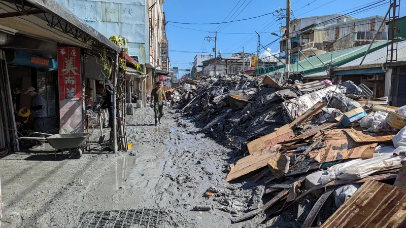花莲县光复乡洪灾过后，居民家中污泥多已清出，道路上堆放大量废弃物。图源：台湾联合新闻网