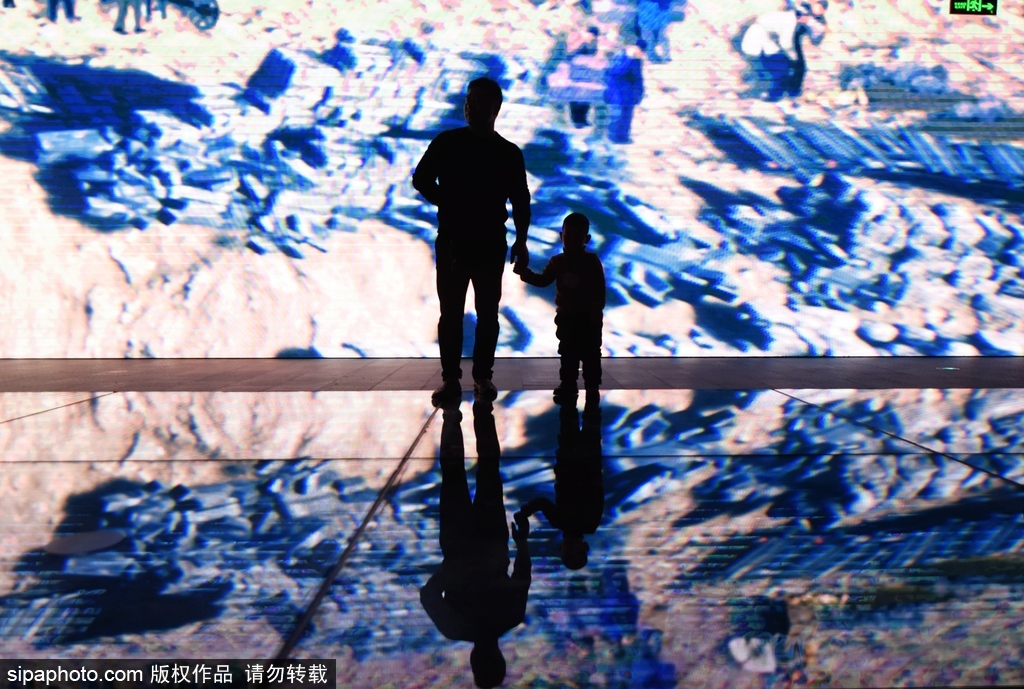 图为观众正在观看古代海塘遗址建筑过程的动画视频