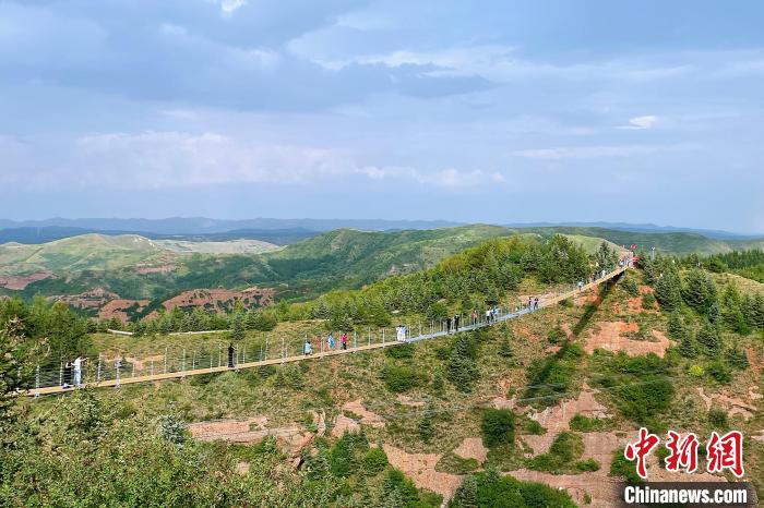 火石寨国家地质(森林)公园内的玻璃吊桥上，游人如织。 中新网记者 李佩珊 摄
