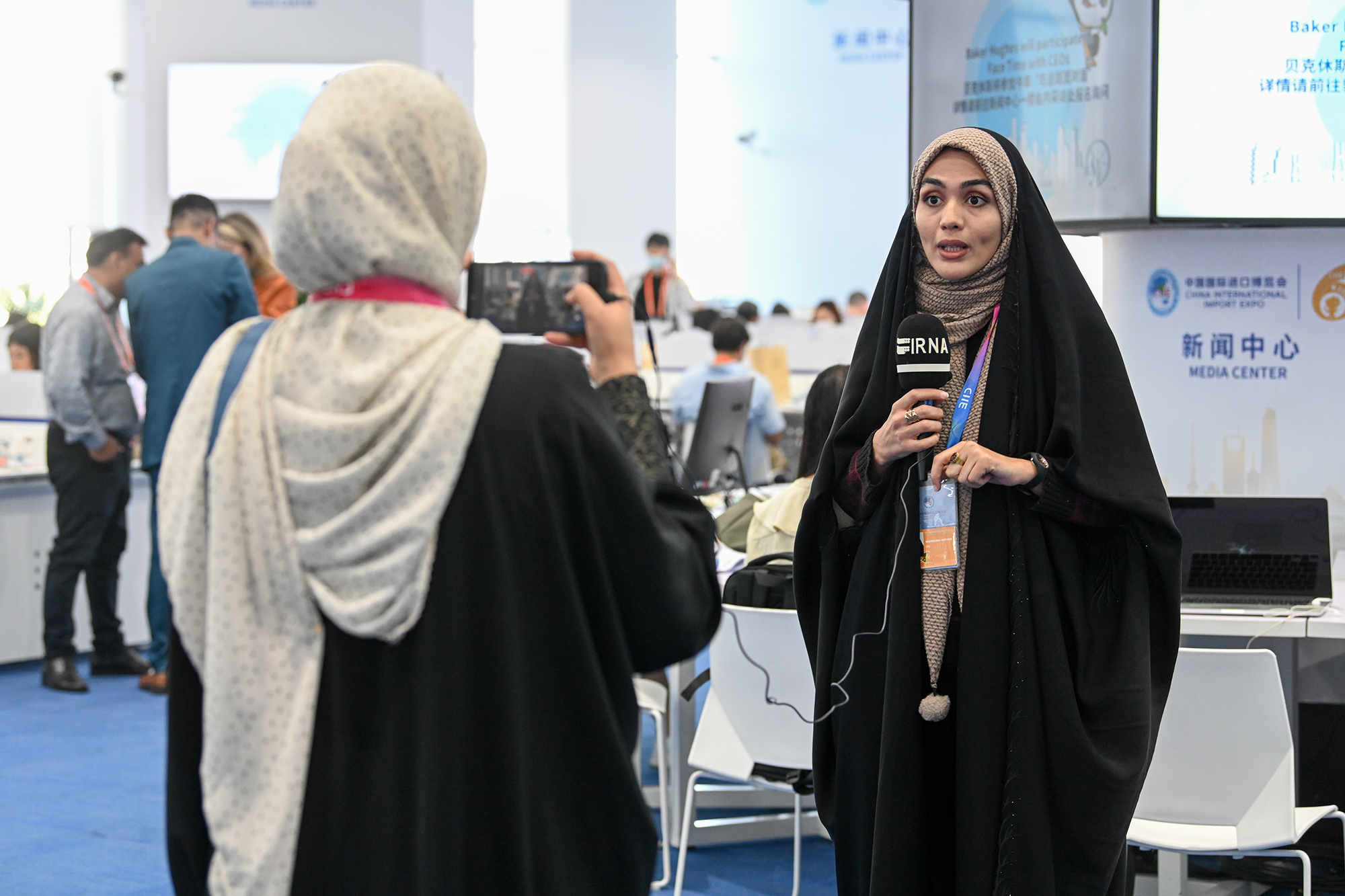 中外媒体记者在新闻中心聚焦第六届进博会开幕式。