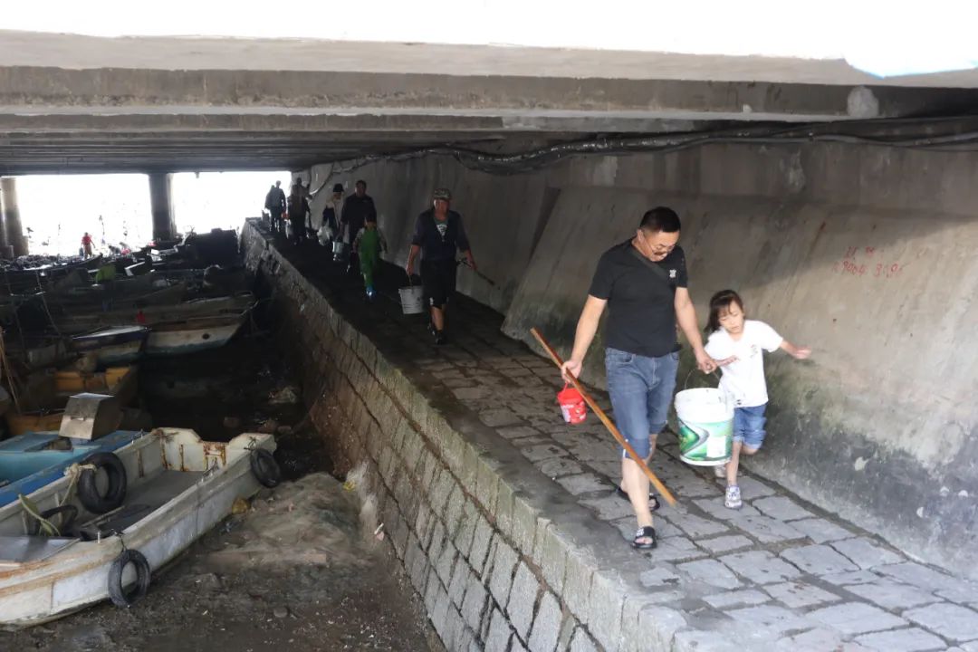 沧口海滩位于环湾路和沔阳路交会处西侧，步行沿板桥坊河桥洞进出过环湾路