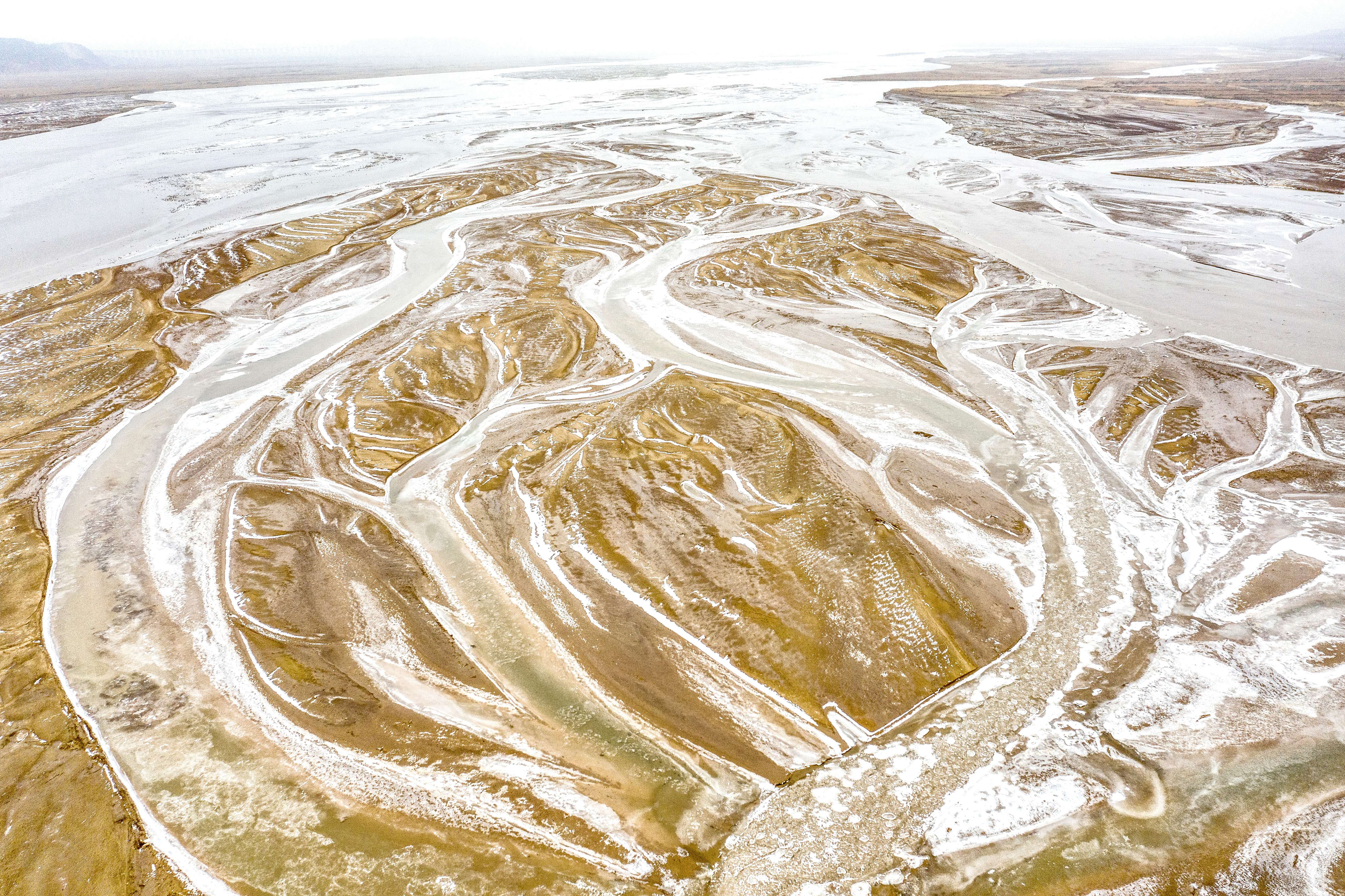 寒冬时节山西万荣黄河河床裸露细流结冰呈现别样美