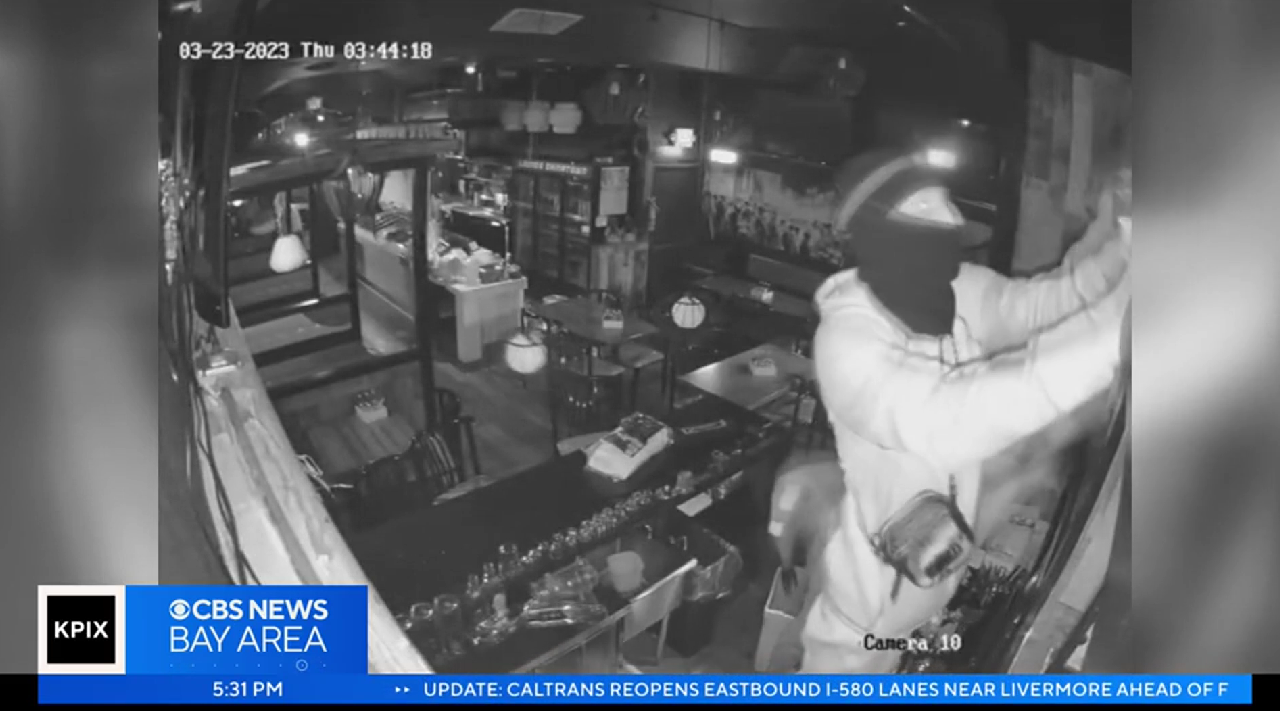 窃贼在餐厅酒柜偷酒（CBS视频截图）