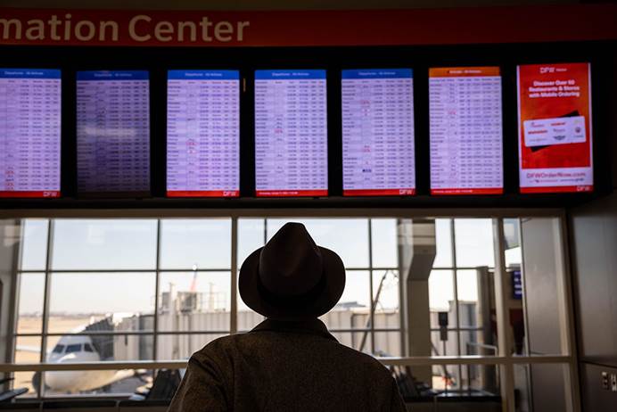 1月11日一名乘客在美国达拉斯-沃斯堡国际机场机场查看航班时刻表 图源：外媒