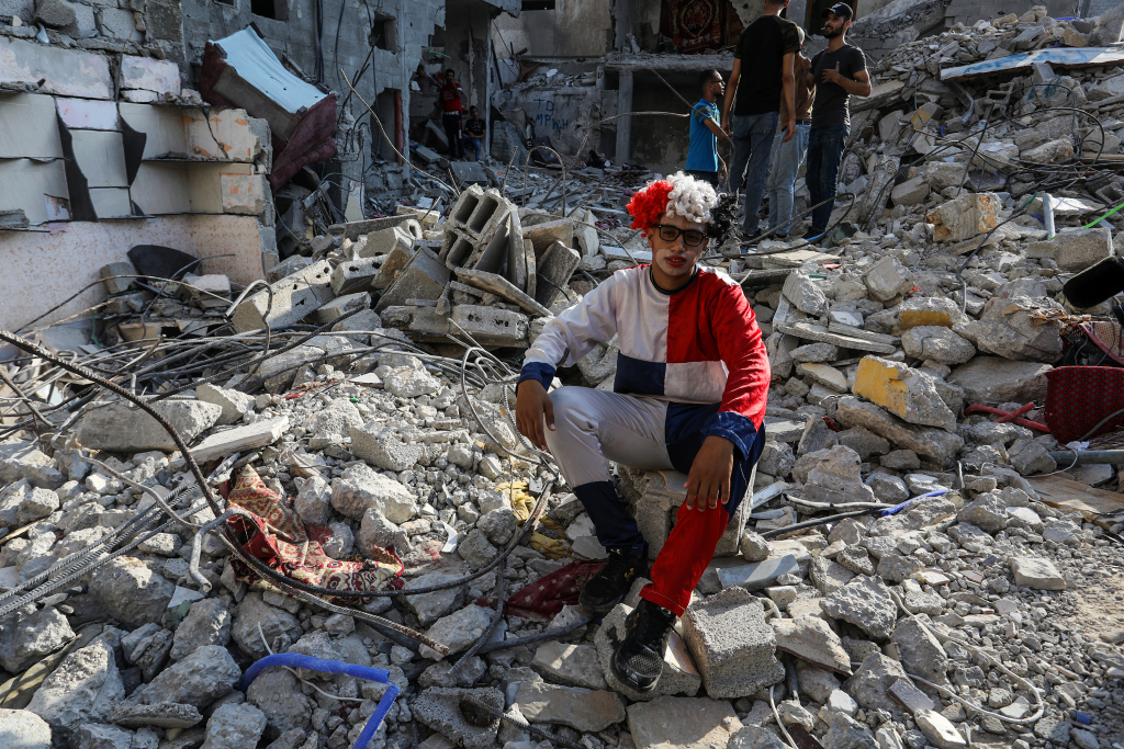 巴以停火后儿童与志愿者在房屋废墟上嬉戏