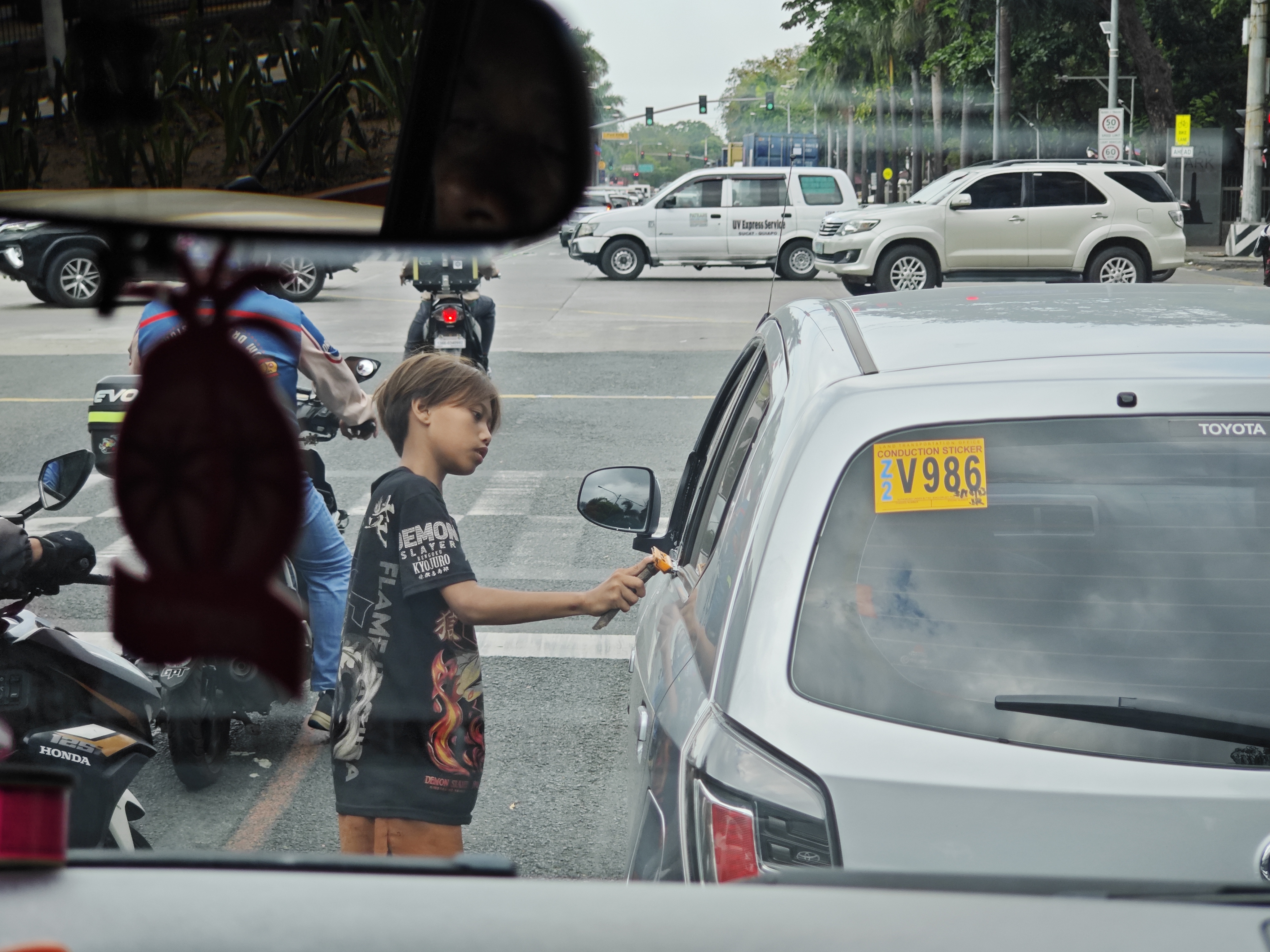 《环球时报》记者在马尼拉街头看到，为了谋生，许多菲律宾儿童不得不走进车流中，为来往的车俩擦车，以此赚取微薄的收入。（樊巍摄）