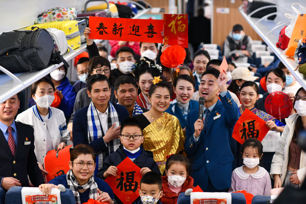 2023年1月19日，奔驰在中老铁路上的C272次列车车厢内，以“中老一家亲，祥和中国年”为主题的列车春晚精彩上演。这是旅客与演员在车厢内合影。新华社记者 江文耀 摄