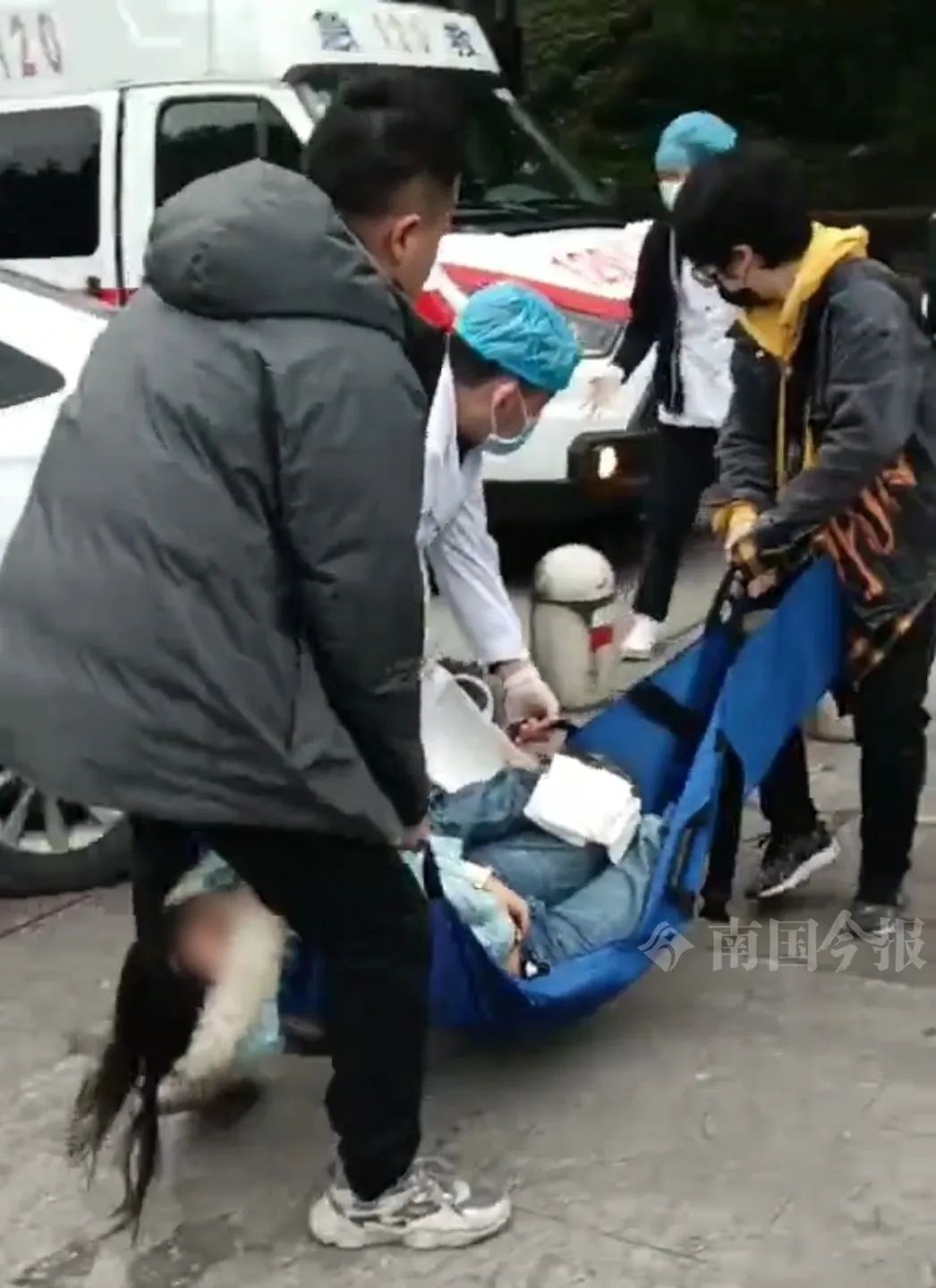 伤者被抬上救护车。视频截图
