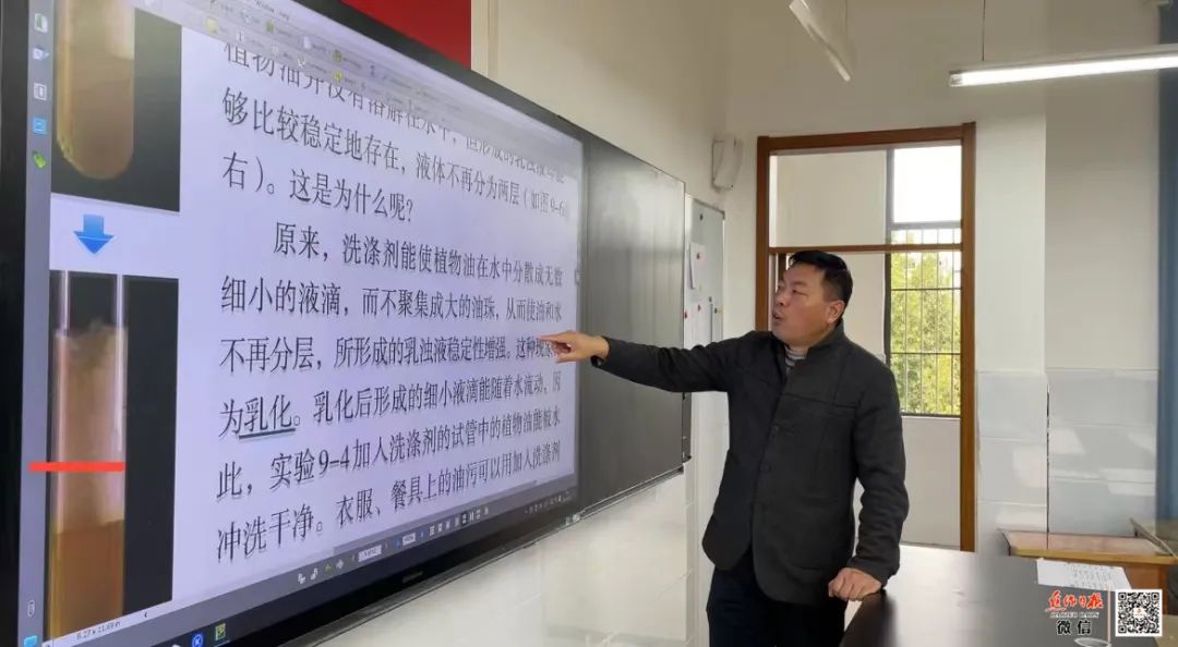 杨委才老师正在讲台上认真上网课。