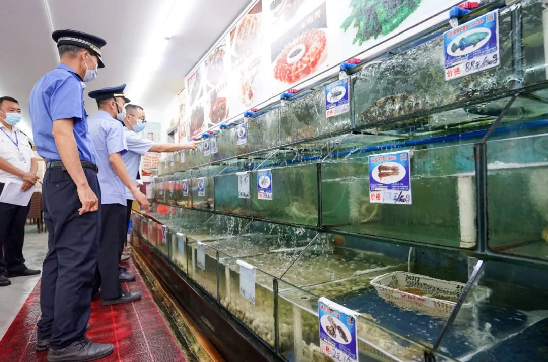 △2021年02月09日,海南三亚市综合行政执法人员在大东海区域检查海鲜排档。