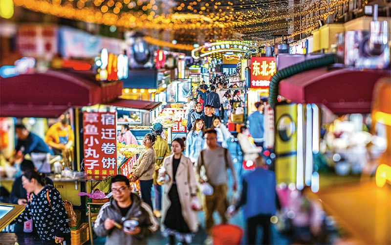 近年来，江苏省宿迁市通过打造“食、游、购、娱”等形式多样的夜间消费市场，让夜经济释放消费新活力。图为2023年4月1日晚，宿城区宝龙广场24街，一个个夜市摊位升腾着“烟火气”、点亮了“夜经济”。 人民图片 陈少帅/摄