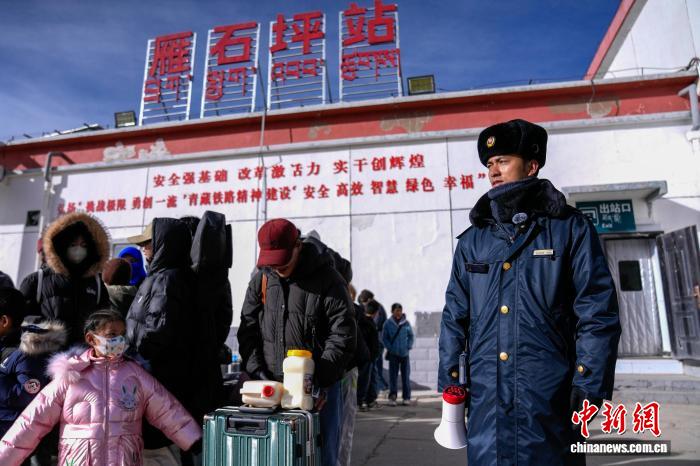 2月10日，中国海拔最高铁路客运站青藏铁路雁石坪站客运员桑杰平措(右一)在火车到达前组织乘客到站台候车。中新社记者 李林 摄
