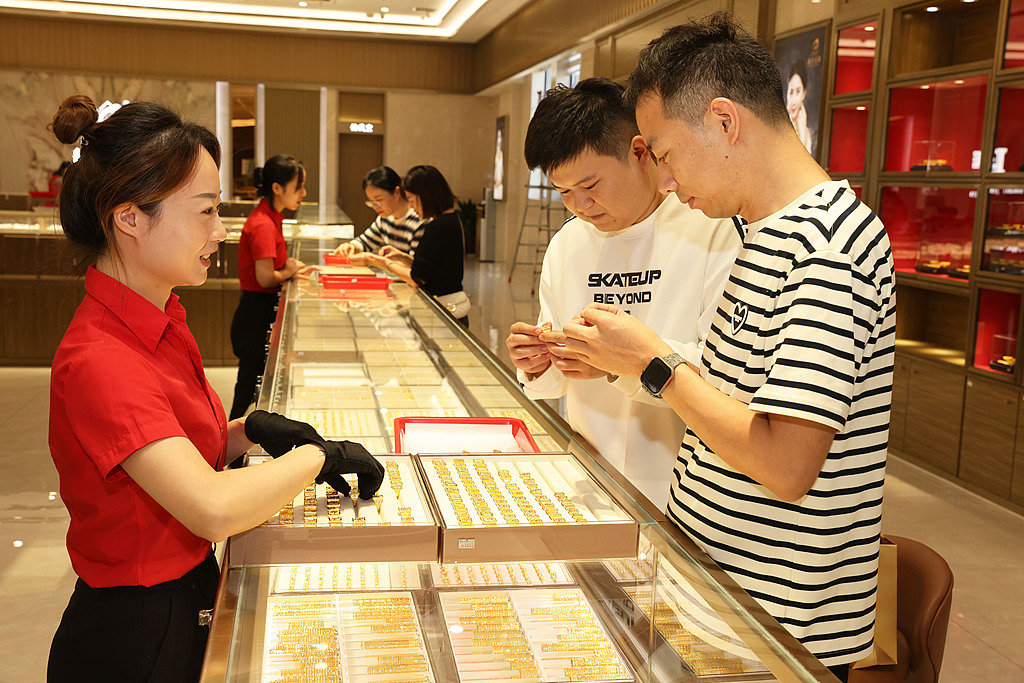 10月18日，金店老板在萧山区瓜沥镇的杭州航民百泰首饰有限公司展厅挑选黄金首饰。（视觉中国）