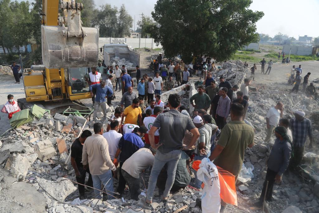 2月28日，在伊朗南部米纳卜市一所被袭击的小学，救援人员和当地居民试图从废墟里营救伤员。新华社/迈赫尔通讯社