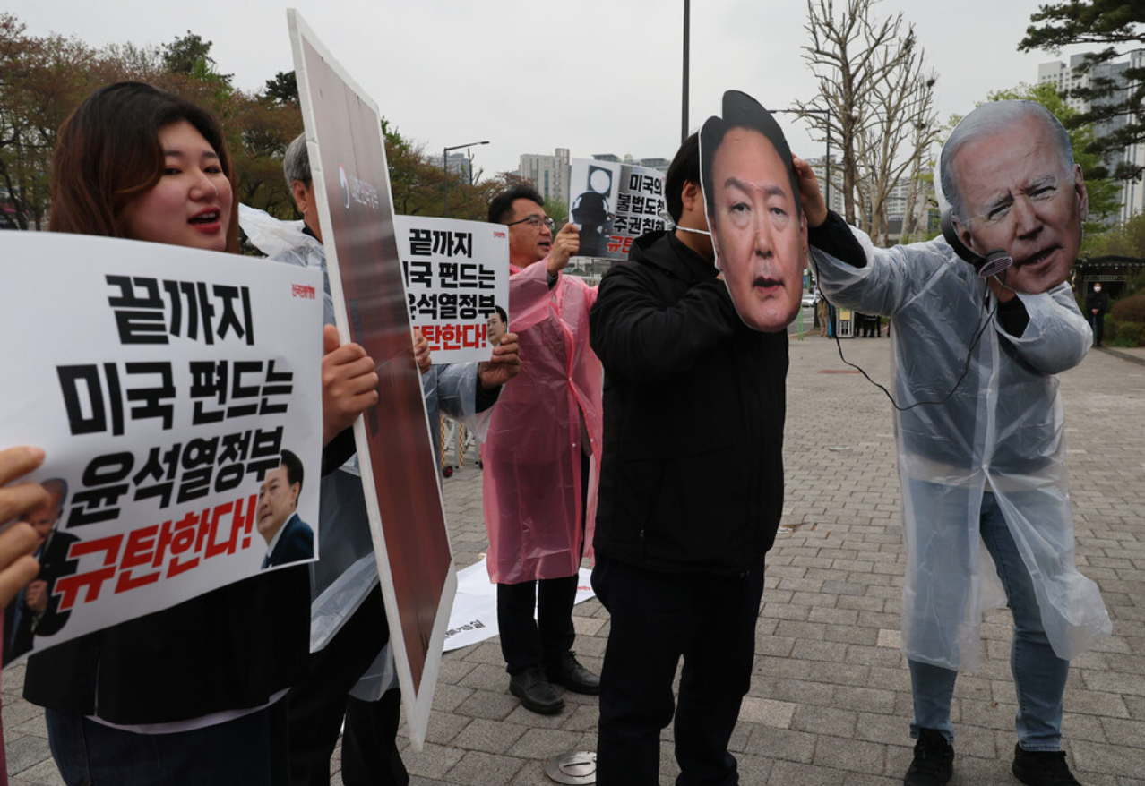 11日下午，在首尔龙山区总统室前，民众召开记者会敦促美国道歉，还有人头戴尹锡悦和拜登面具。图源：韩媒