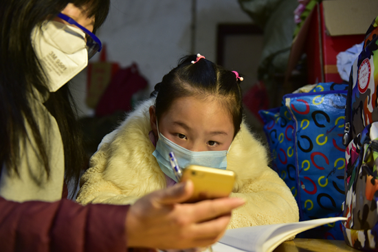 3月3日,合肥市十里庙小学三一班班主任王传华(左)定期到李小苒家对她进行线下辅导。