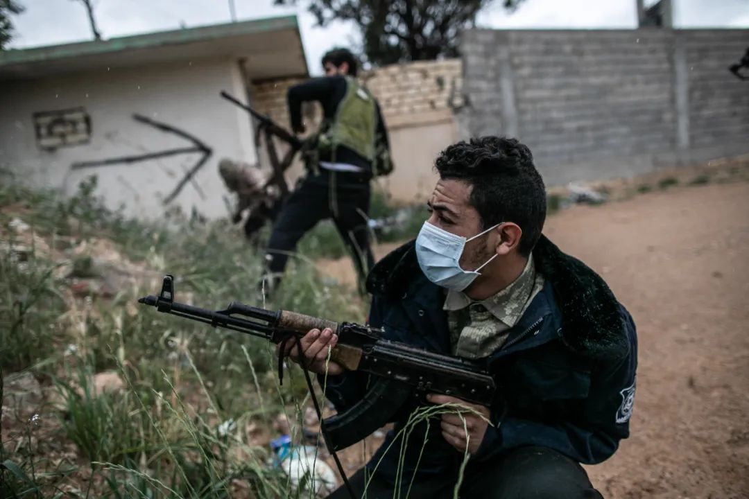 3月25日，在利比亚的黎波里，利比亚民族团结政府武装人员戴着口罩战斗。新华社发（阿姆鲁摄）