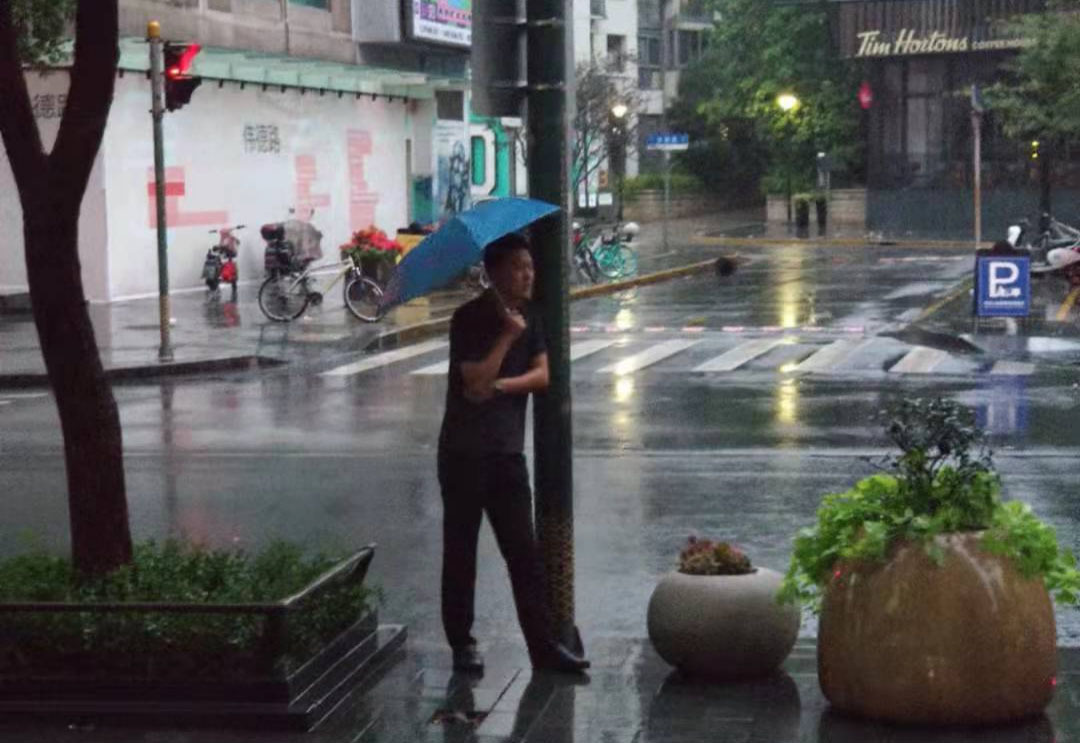 中卫市沙坡头区公安分局刑侦大队副大队长吴海洋在雨中等待失踪人员章某现身。（图片来源：受访者提供）