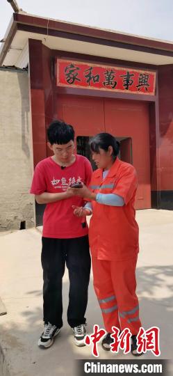 图为任旭明和母亲在接受媒体电话采访。　陈林 摄