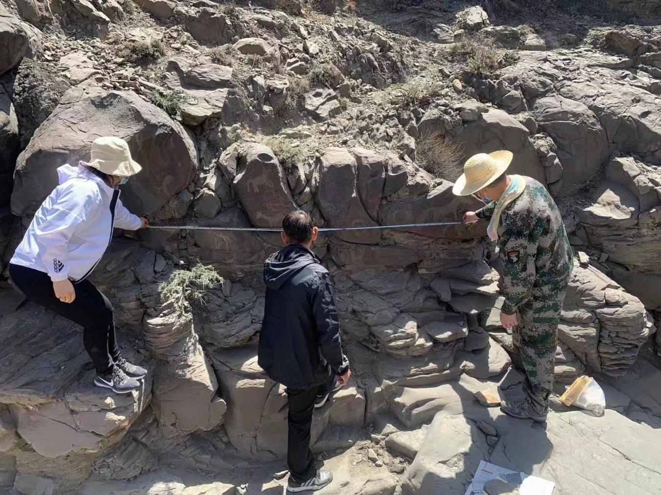 科研人员正在对岩画进行勘察。