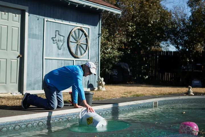 2月20日，在美国得克萨斯州矿泉井城，一名男子在自家泳池内打水为马桶蓄水。新华社/路透