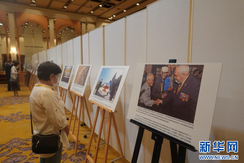 座谈会现场,参会者正在观看纪念抗战胜利80周年图片展。(梁晨 摄)