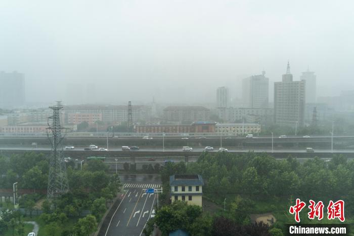 图为暴雨中的城市。中新社记者 李超庆 摄