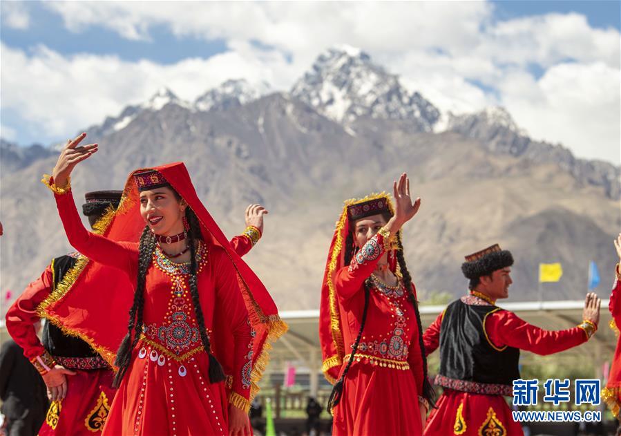 歌舞演员在新疆喀什地区塔什库尔干塔吉克自治县的端午节群众文体活动上表演