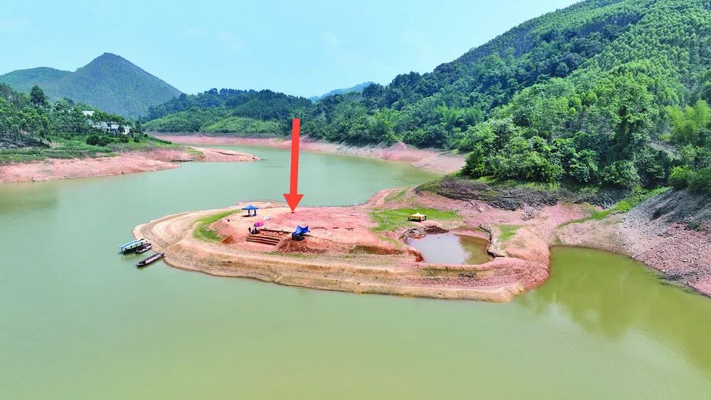 发现战国古墓的达洪江水库库区半岛(箭头处为铜鼓发掘位置)。覃蔚峰 摄