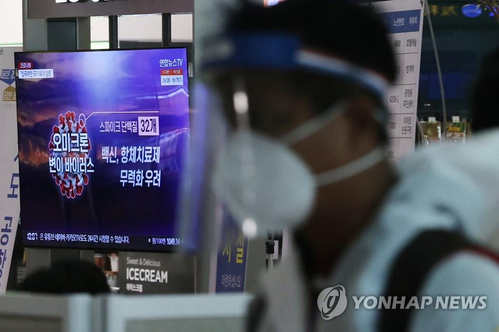 11月29日上午，一名身穿防护服的旅客通过仁川国际机场入境。图自韩联社