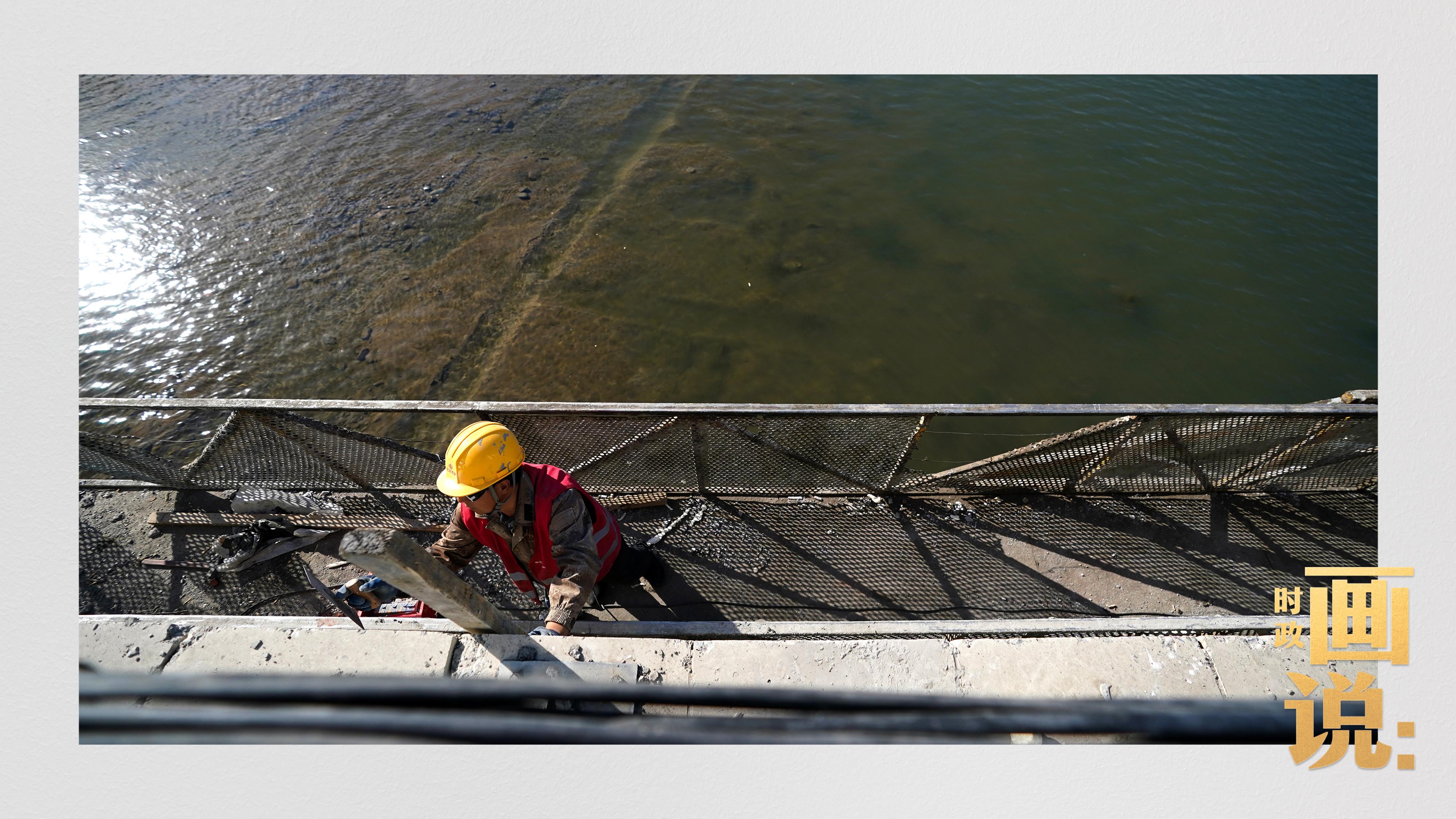 △工人在重新加固的桥梁上加装路灯。水峪嘴村,北京。冬日里的永定河静静流淌,一度受灾严重的流域沿线正在重回平静。