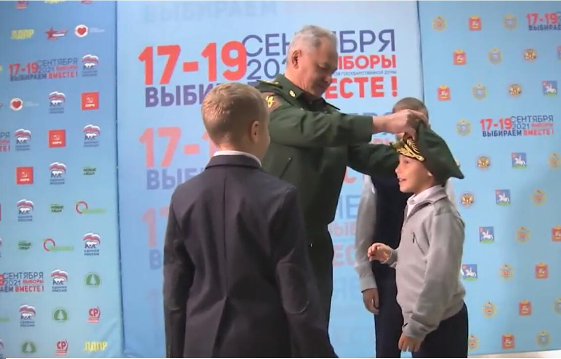 绍伊古给小男孩戴上军帽 图源：俄媒视频截图