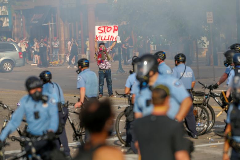 27日，明尼阿波利斯一名示威者与警察对峙（路透社）