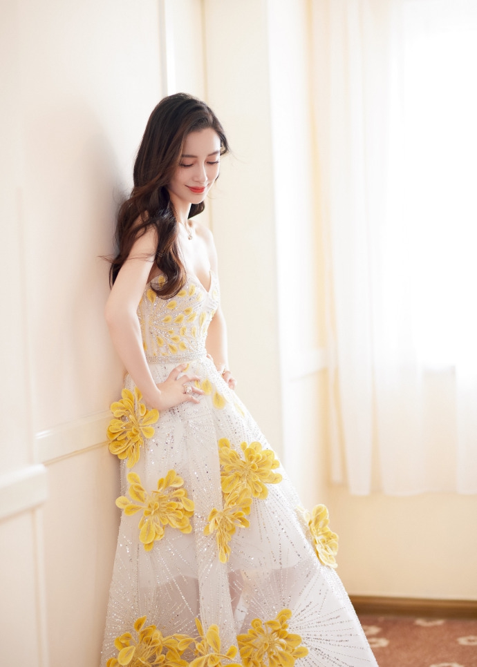 6月24日,杨颖工作室晒出一组夏日礼服写真她身着繁花抹胸纱裙