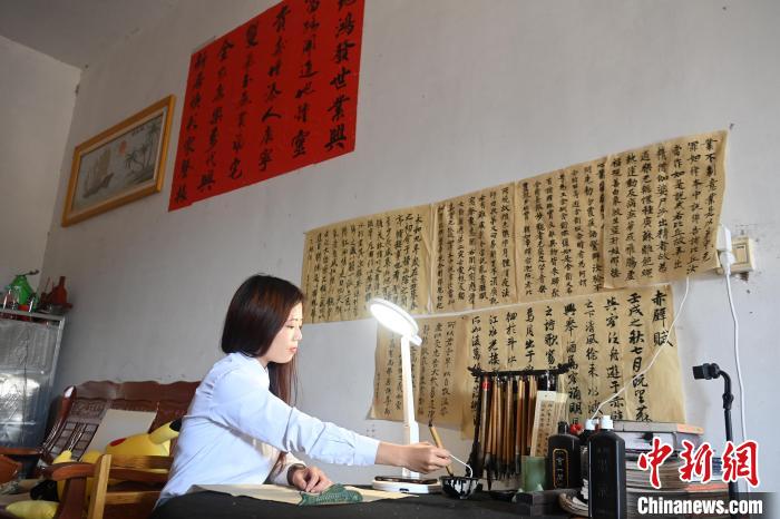 罗意兰家中贴满了自己誊写的书法作品。 王以照 摄